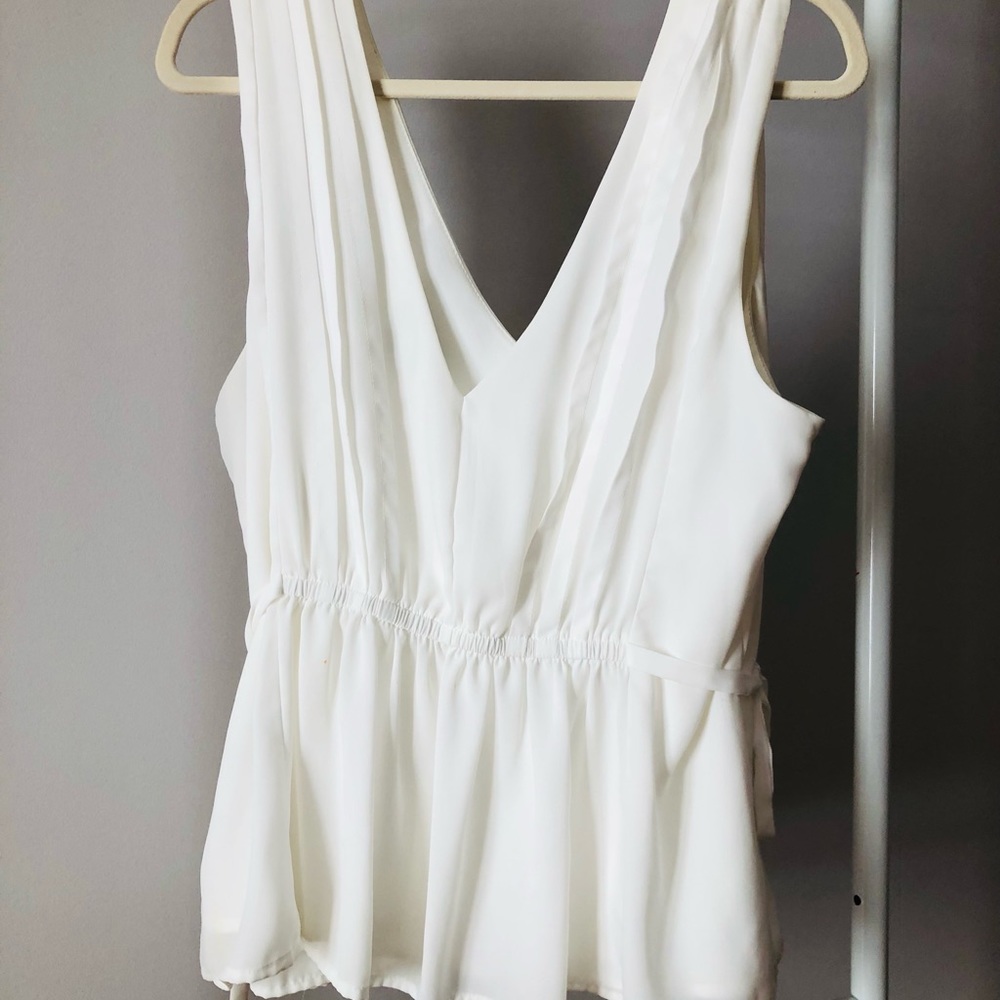 Cream sleeveless v-neck blouse with pleats and cinched waist